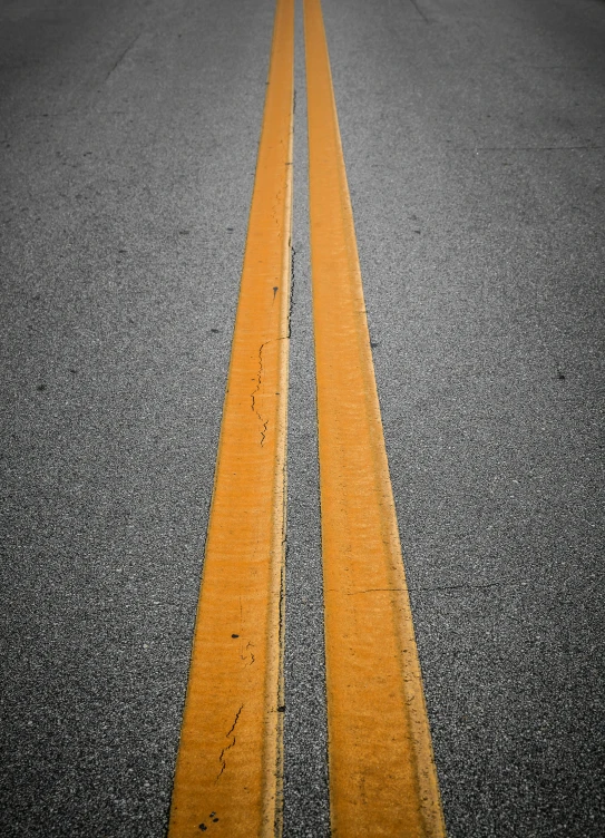 a pair of yellow street dividers line an empty road