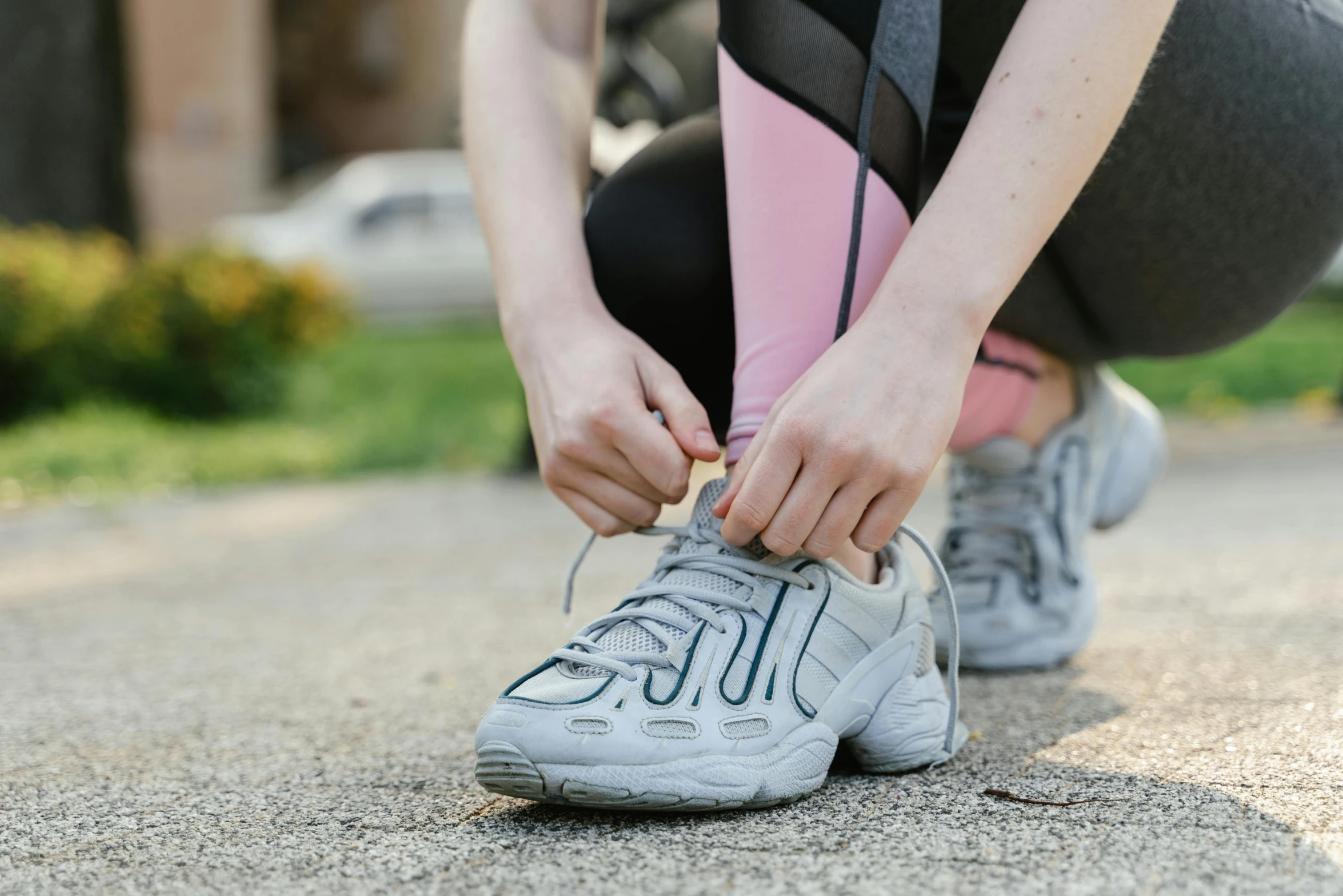 a person tying shoes with their hands while squatting