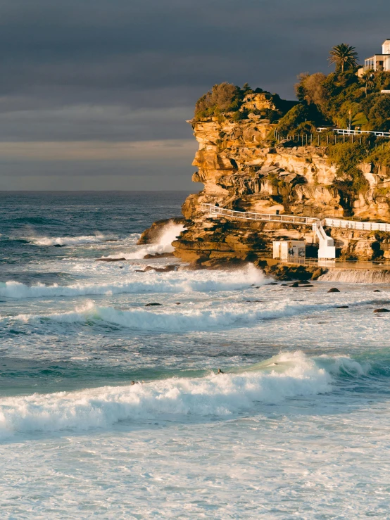 the coast is next to a rock cliff with houses on it