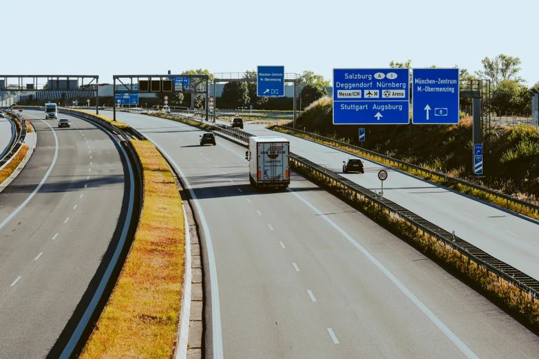 an empty highway with multiple lanes surrounded by trees