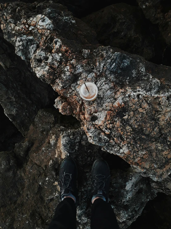 two persons standing on rocks in the woods