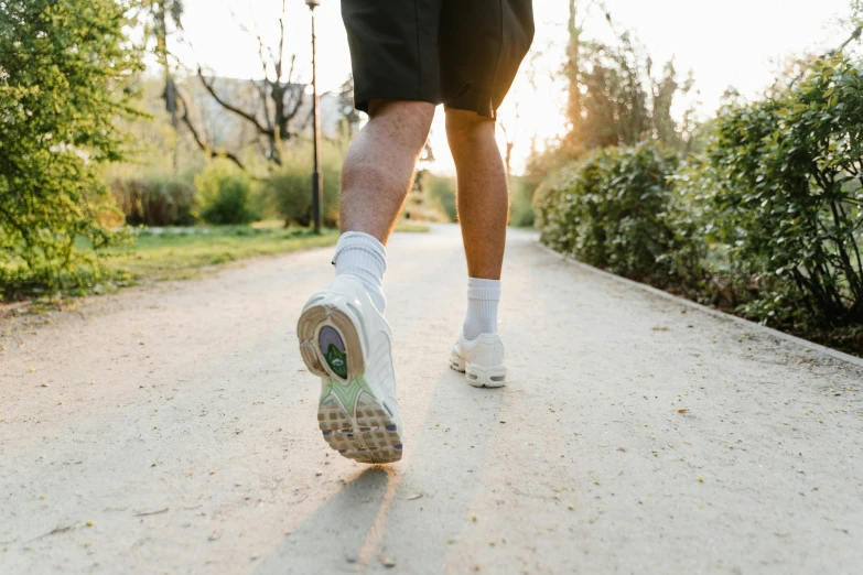 the man in white shoes is walking down the road