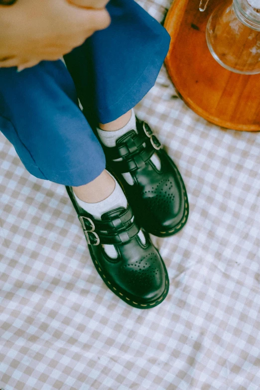 child's legs on a table next to black shoes