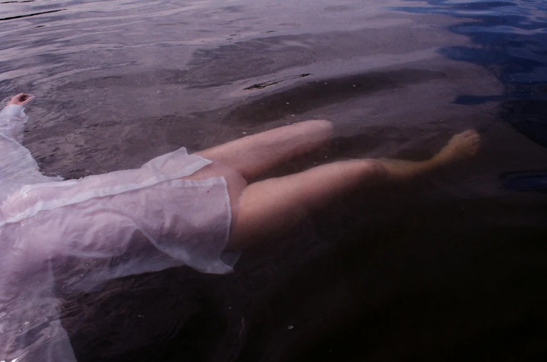 person floating in water with short skirt and open toe