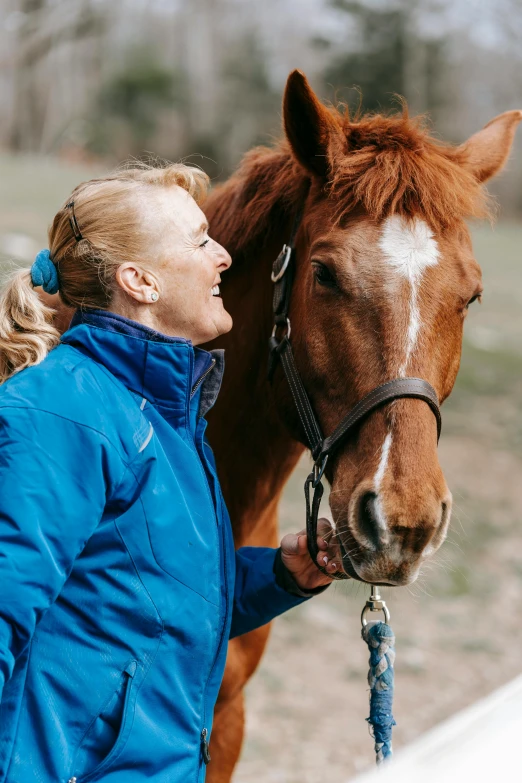 a woman is petting a horse with her hand