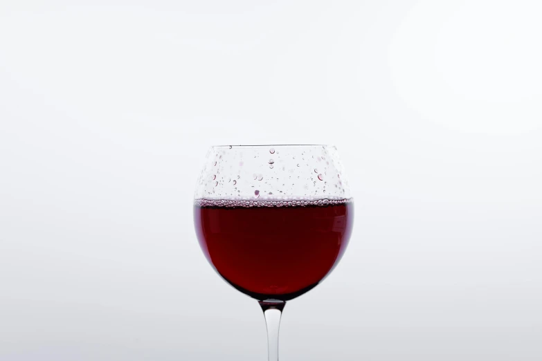 a glass with a wine in it sitting on a table