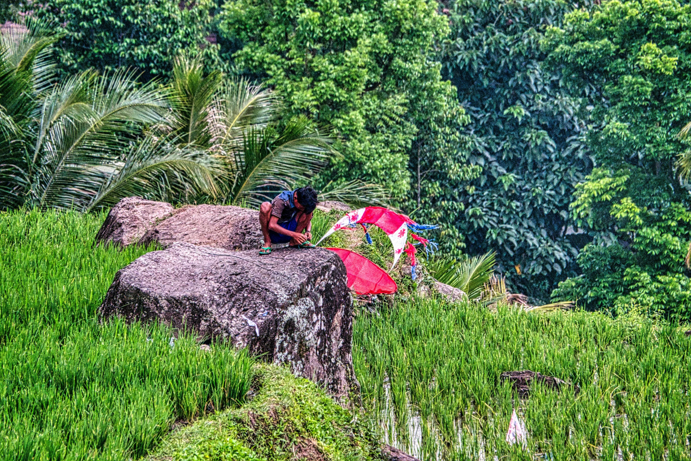 two men are sitting on a large rock