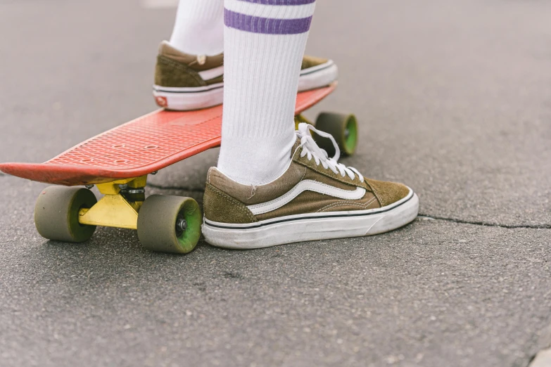 the legs of someone riding a skate board with their shoes