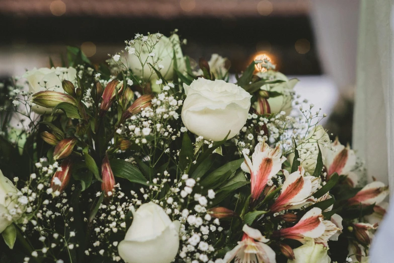 some white flowers are in a bouquet with red and white flowers