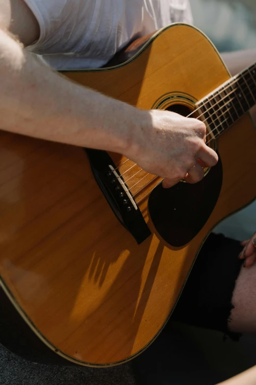 a close up of someone playing guitar in the street