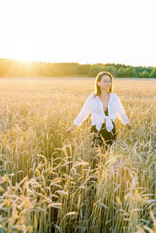 a woman in a large field of tall grass