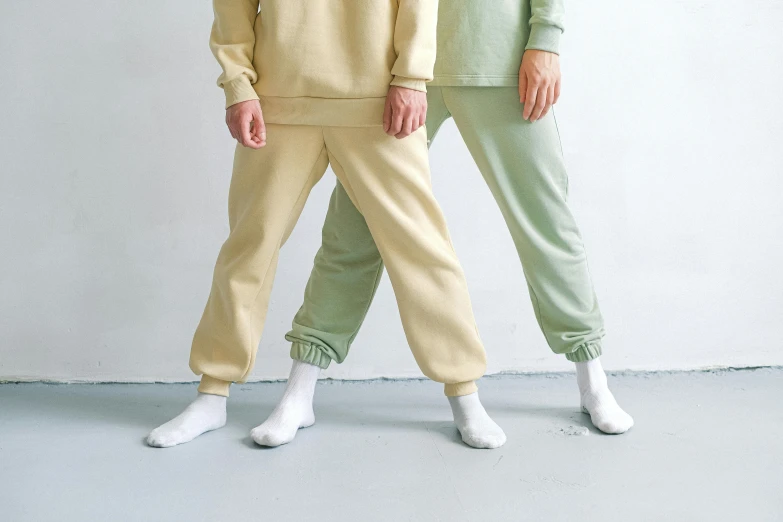 two young men in pajamas posing in front of a wall