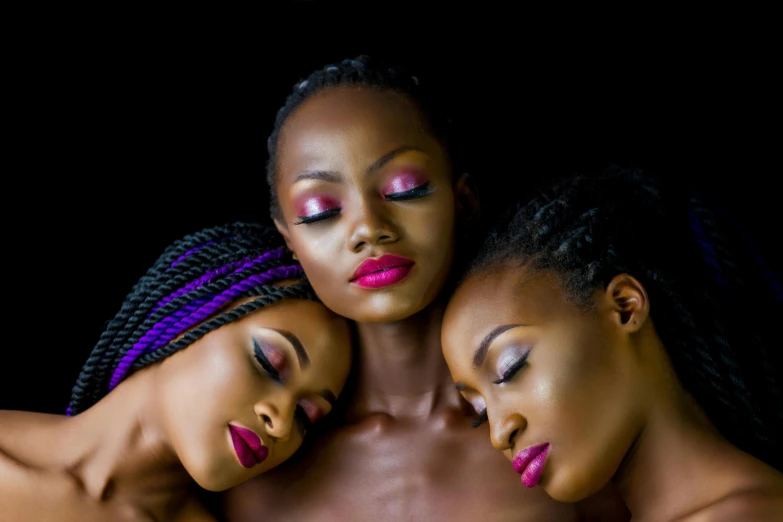 three women with makeup are cuddling each other