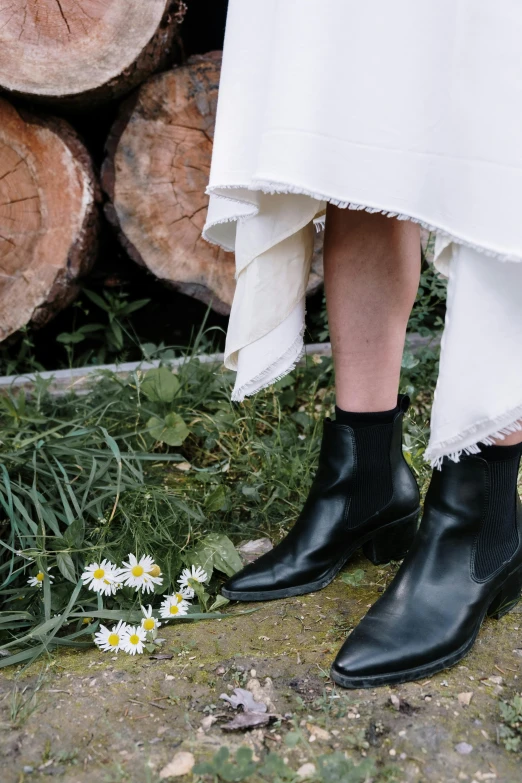 the legs and feet of a person wearing black leather boots