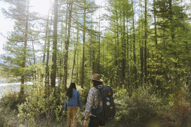 the man and woman are walking together through the woods