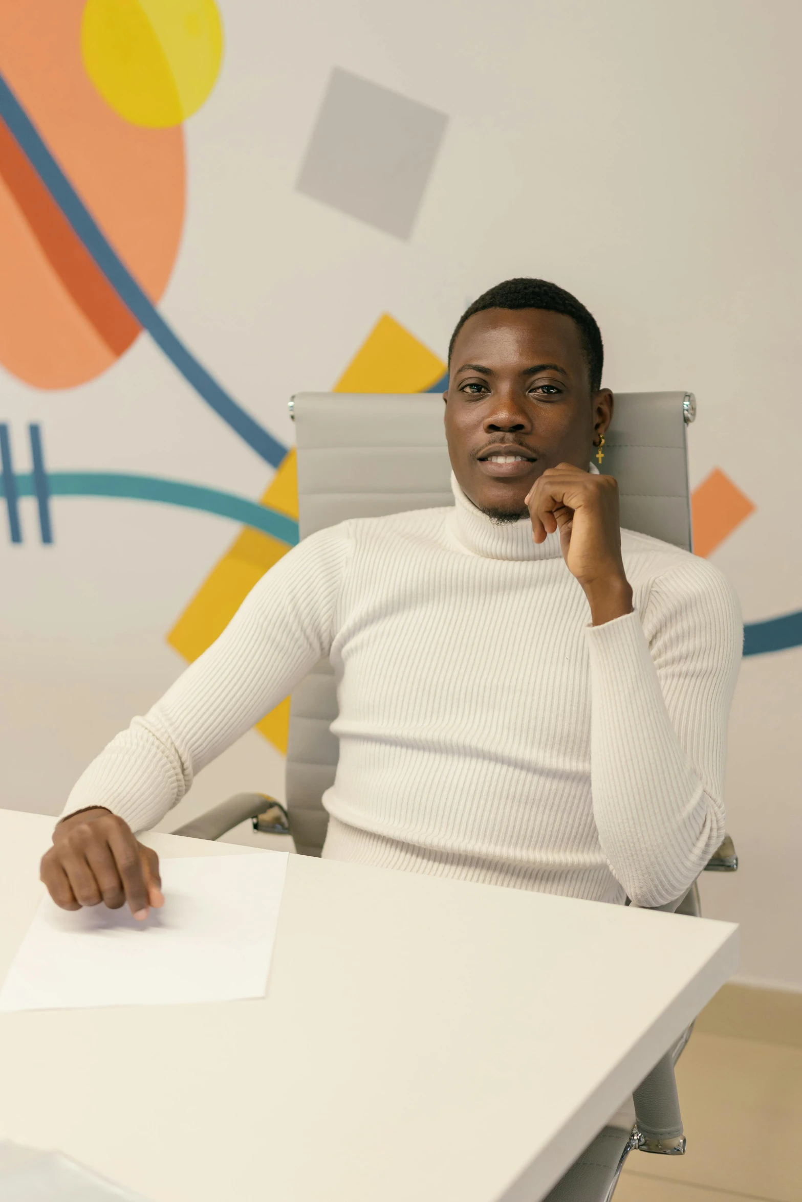 a man sits in an office chair and looks at the camera