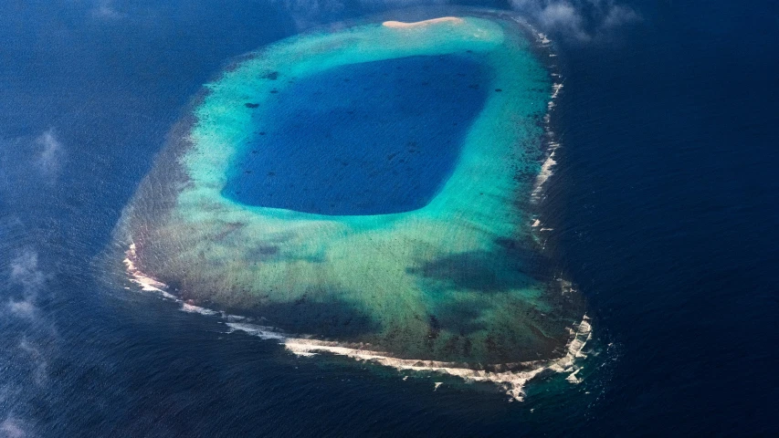an aerial s of a blue sea and island in the water