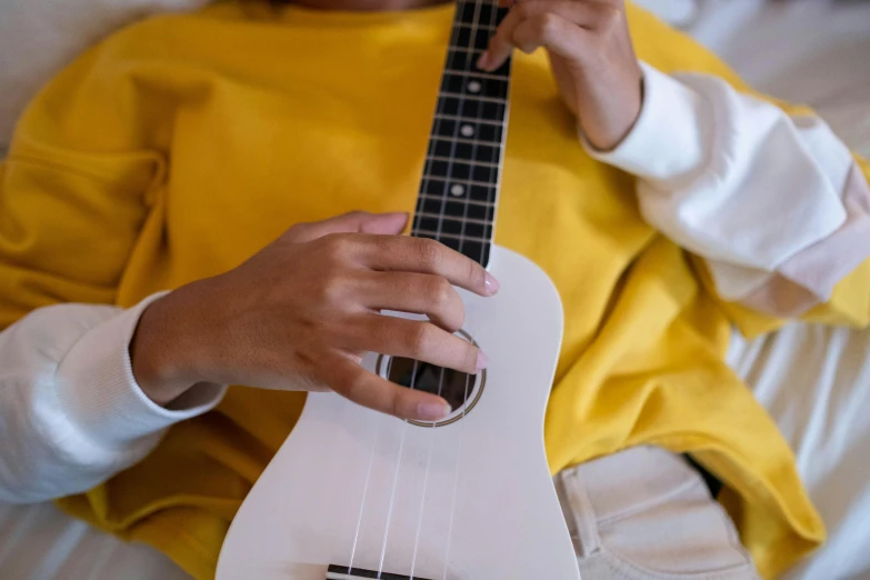 person sitting down and holding onto a small white instrument