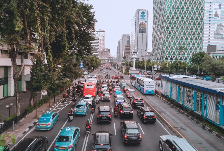 a street filled with lots of traffic next to tall buildings