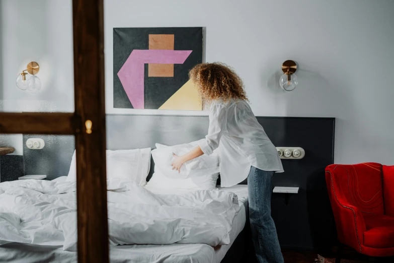 a woman jumping on top of a bed in a bedroom