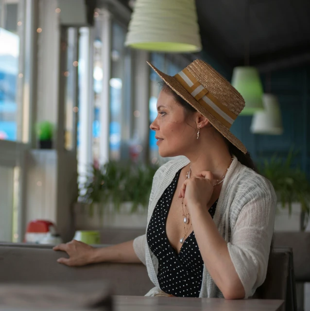 a woman wearing a hat sitting down at a table