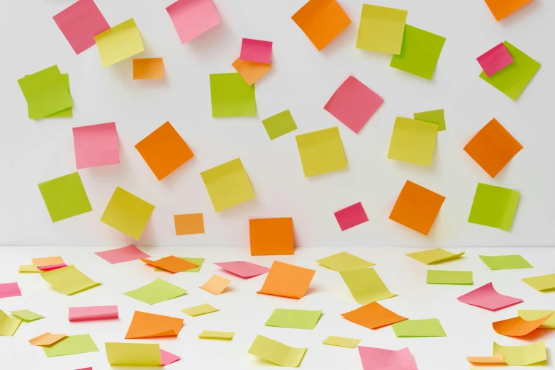 colorful pieces of stick paper flying away from a wall