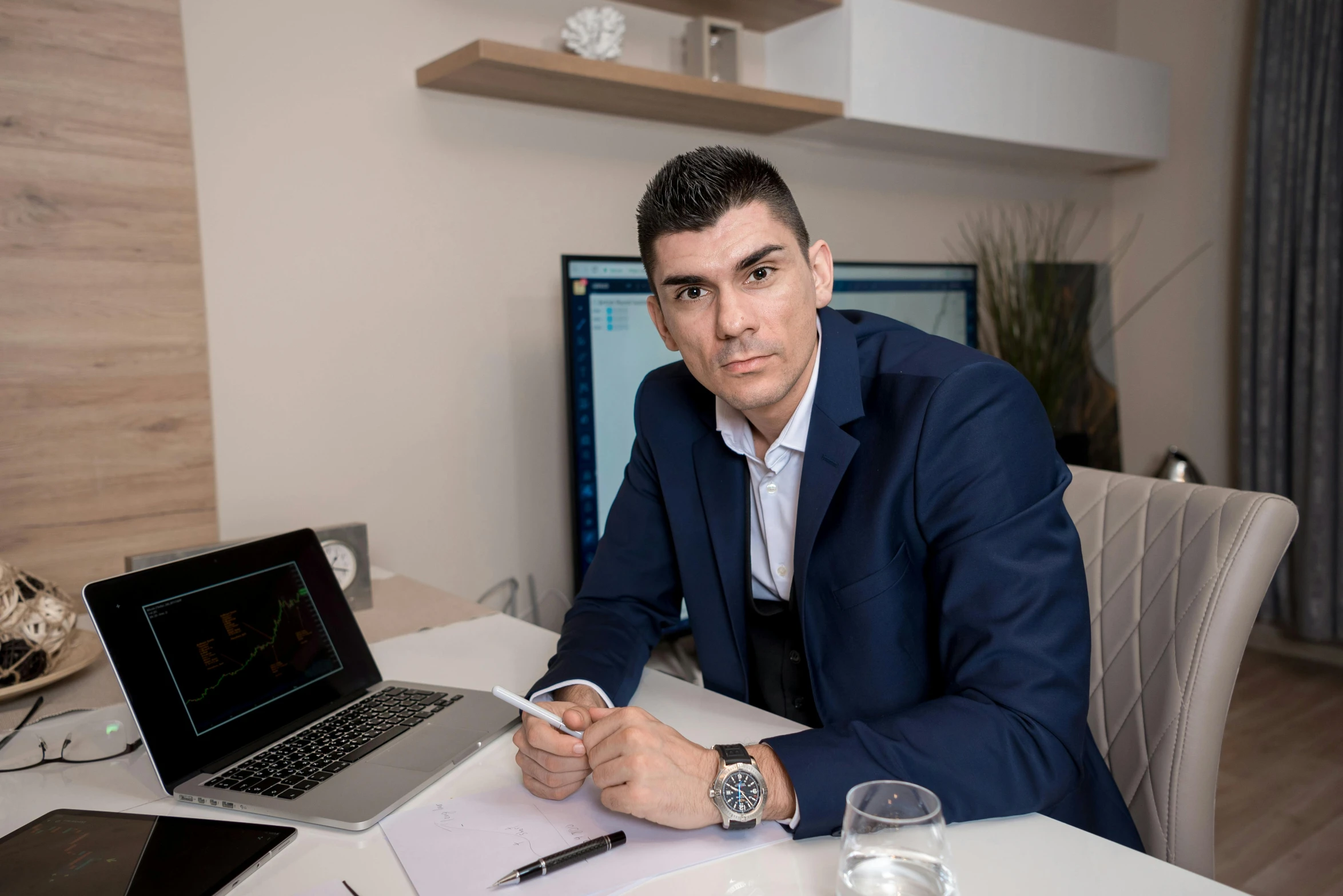 a man is sitting at a desk while looking at the camera