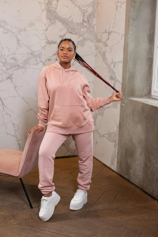 a woman in pink stands with a tennis racket behind her