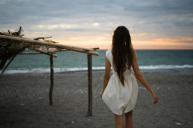 a young woman walking down the beach