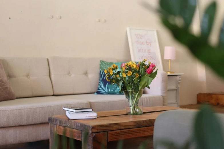 a flower vase is on the table by a couch