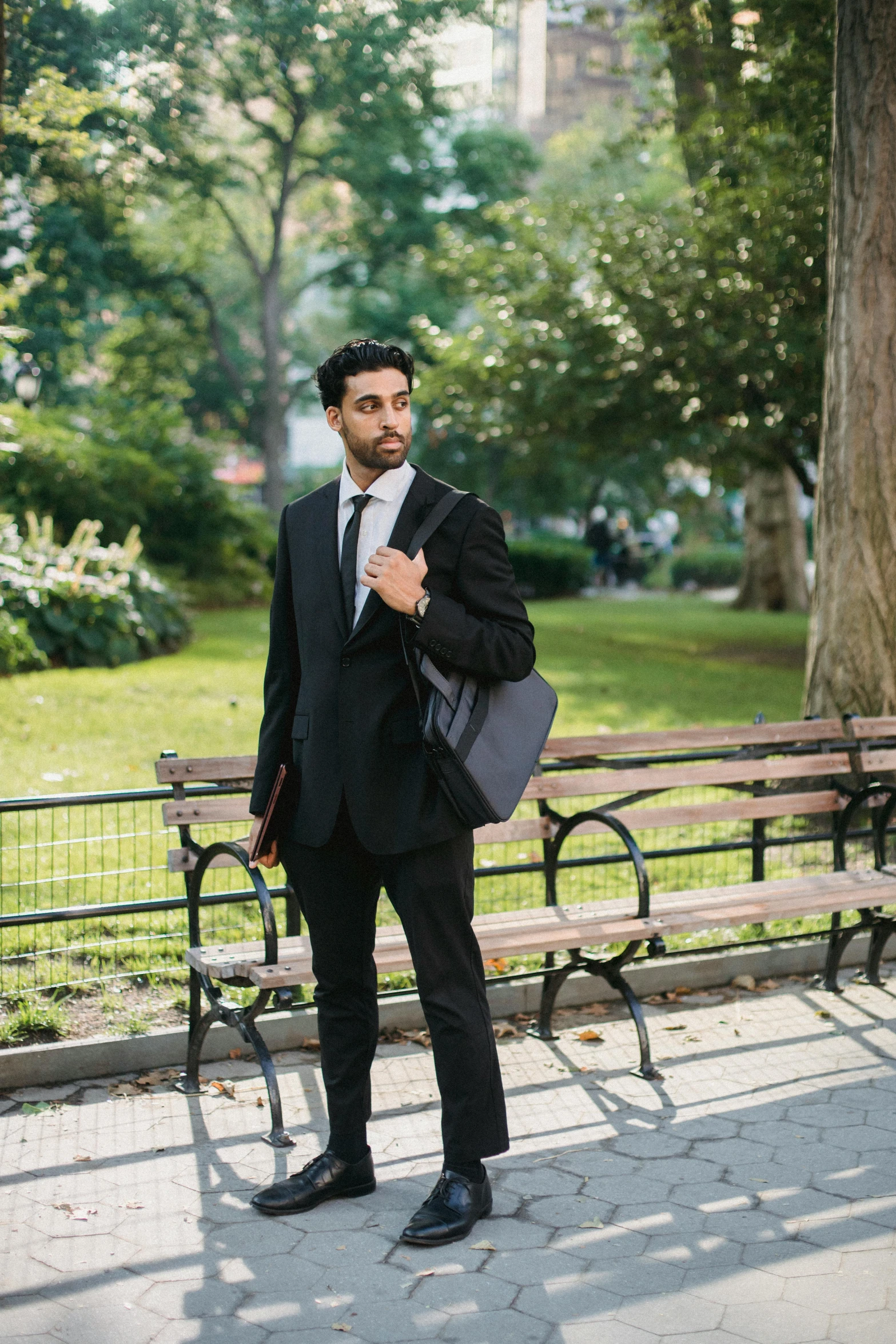 the young man poses on a park bench