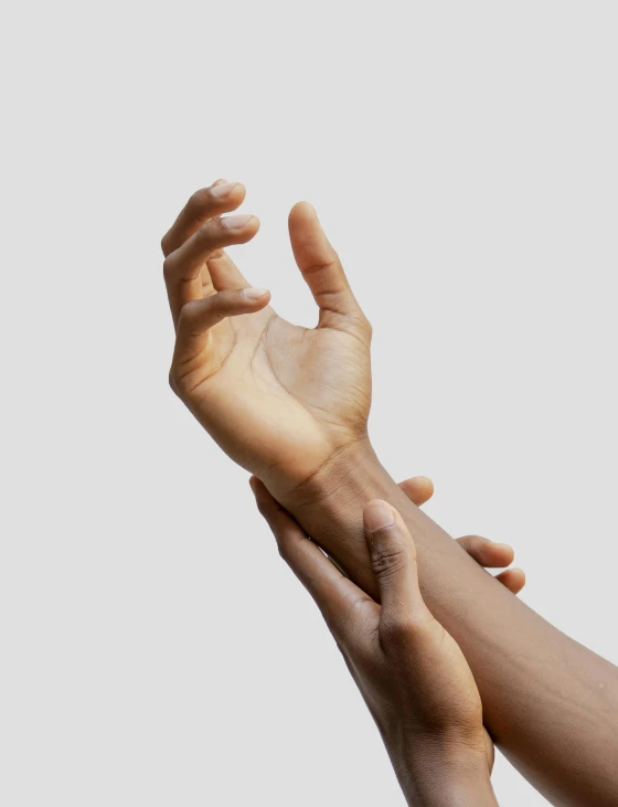 a pair of hands holding each other near one another