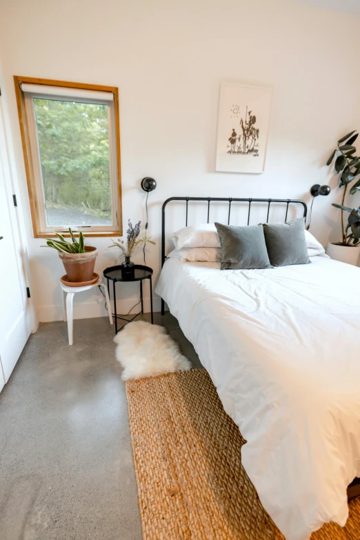 a small white bedroom with a bed and window