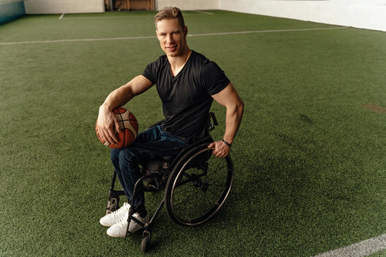 the man is holding a ball in his wheelchair