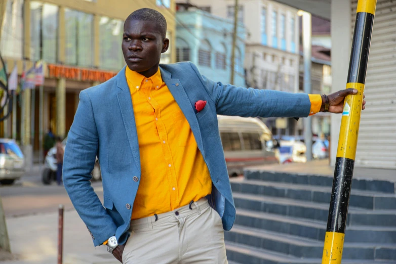 a man is posing on the stairs with a blue jacket