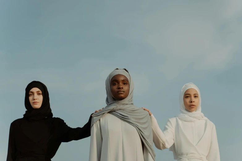 three women in identical outfits posing for the camera