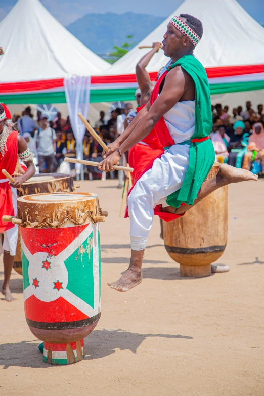 a man playing the drums while standing by a drum