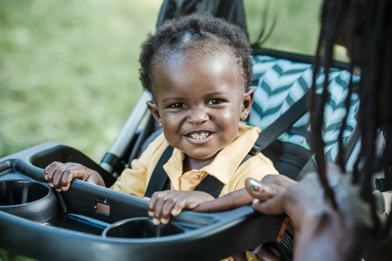 the young child is smiling as it hes the stroller