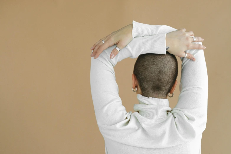 the back view of a person, arm resting on his head