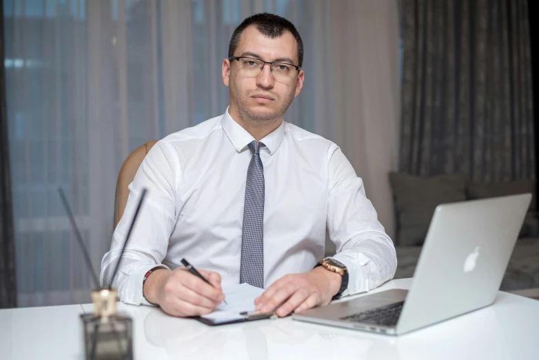 a man is sitting at a desk with a laptop