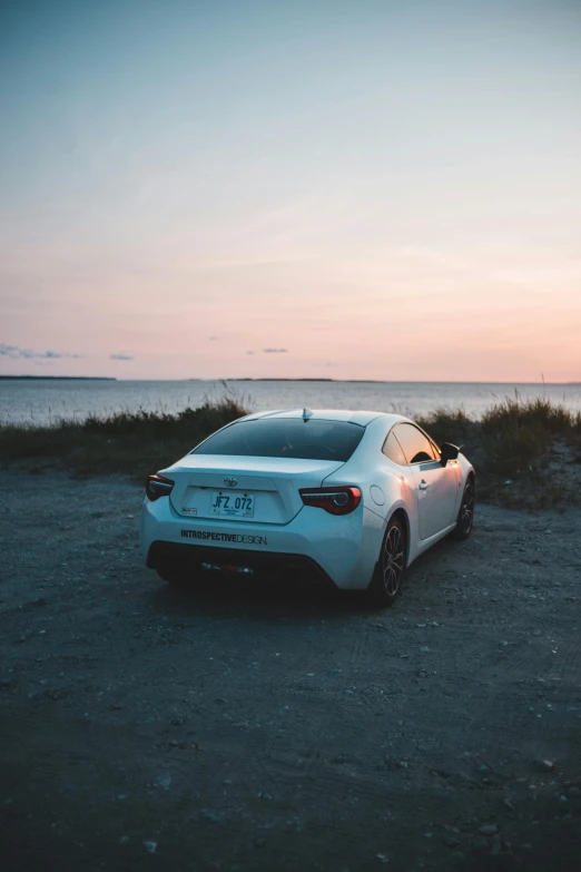 a car parked on a gravel road near water