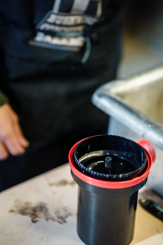 a cup of water on the counter and someone holding it