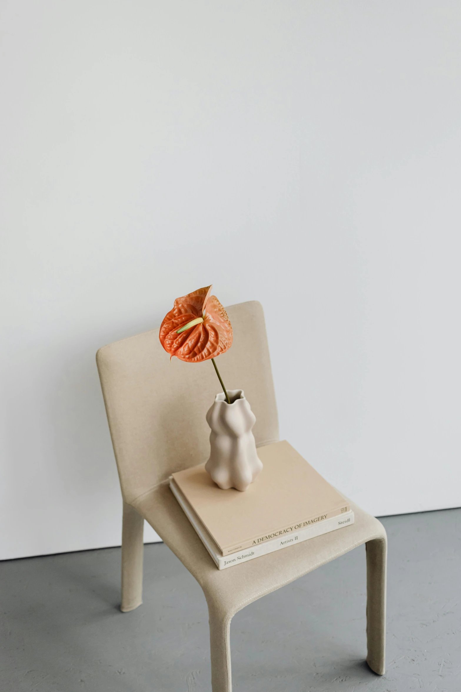 the chair is white and holds a flower