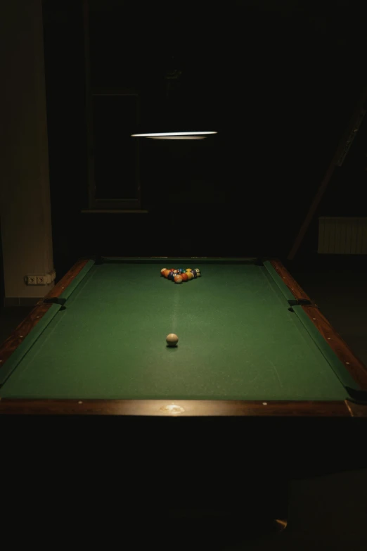 a dark room that has a pool table in it