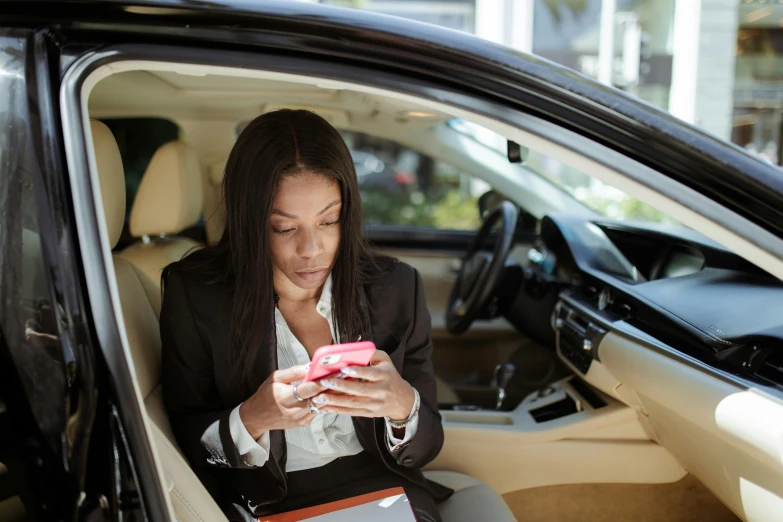 a woman looking at her cell phone in her car