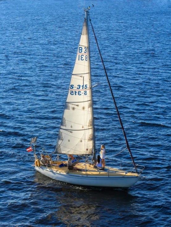 a sailboat with several passengers on the water