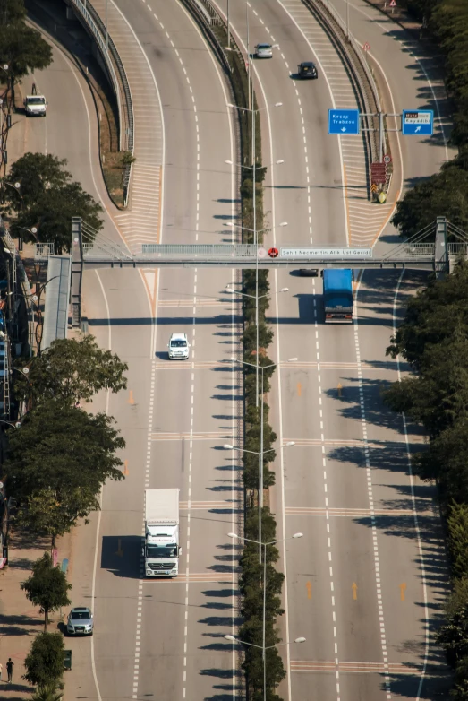 cars driving down the road and a bridge over it