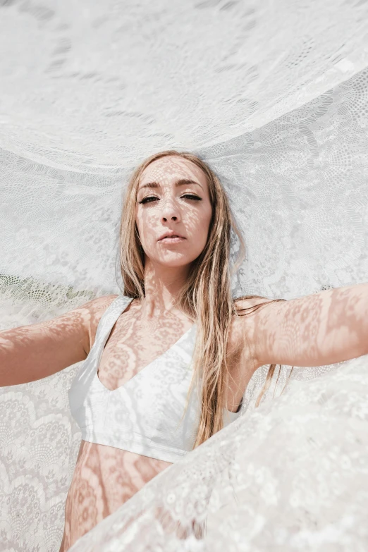 a woman laying on top of a white beach