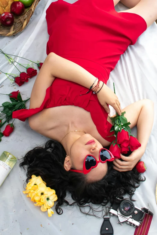 the lady is laying on the bed with all her red flowers