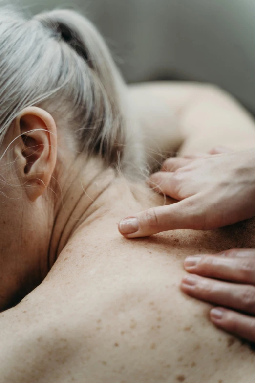 a woman in an exam room getting a back massage